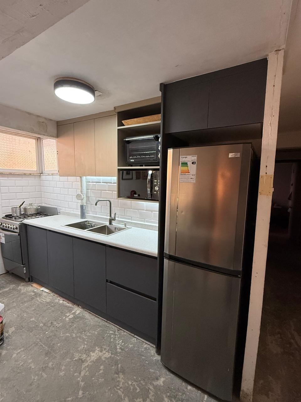 Cocina personalizada con muebles oscuros y terminación madera